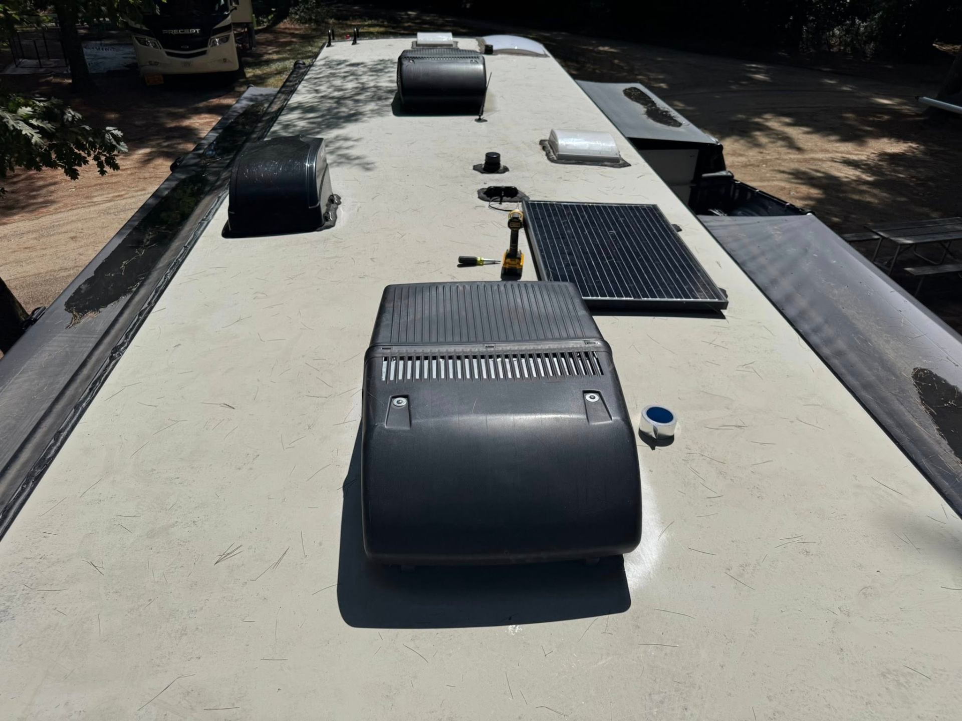 Multiple rooftop RV A/C units and solar panel installed on motorhome roof