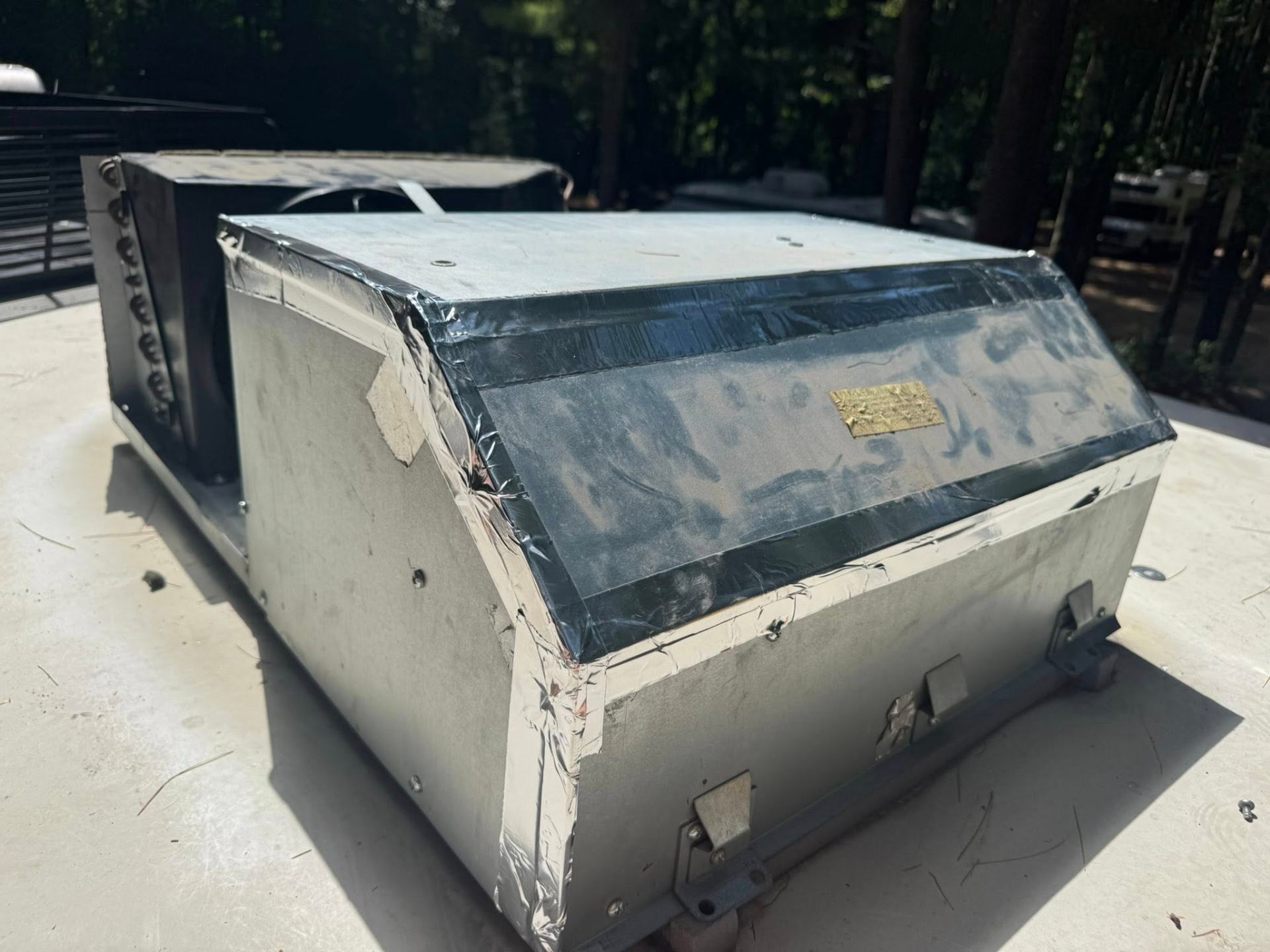 Close-up of RV rooftop A/C unit showing condenser housing during inspection