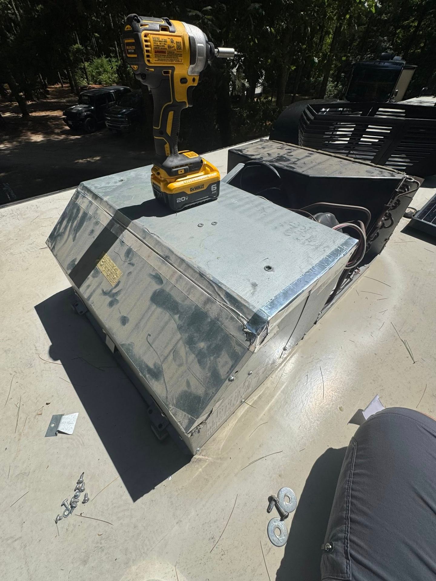 RV rooftop A/C unit being removed with DeWalt impact driver during replacement service