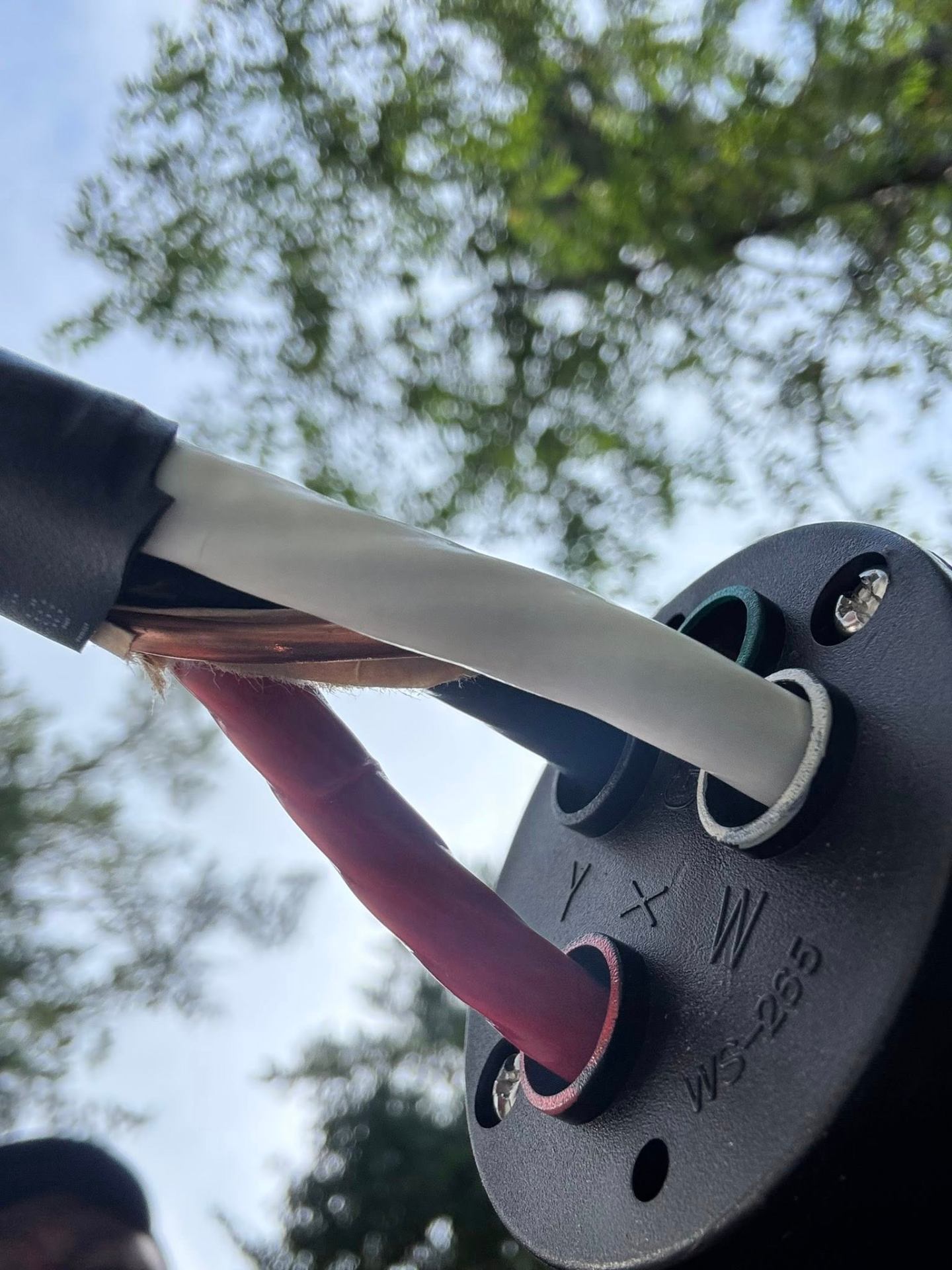Close-up of RV power connector with color-coded wires being routed into junction ports