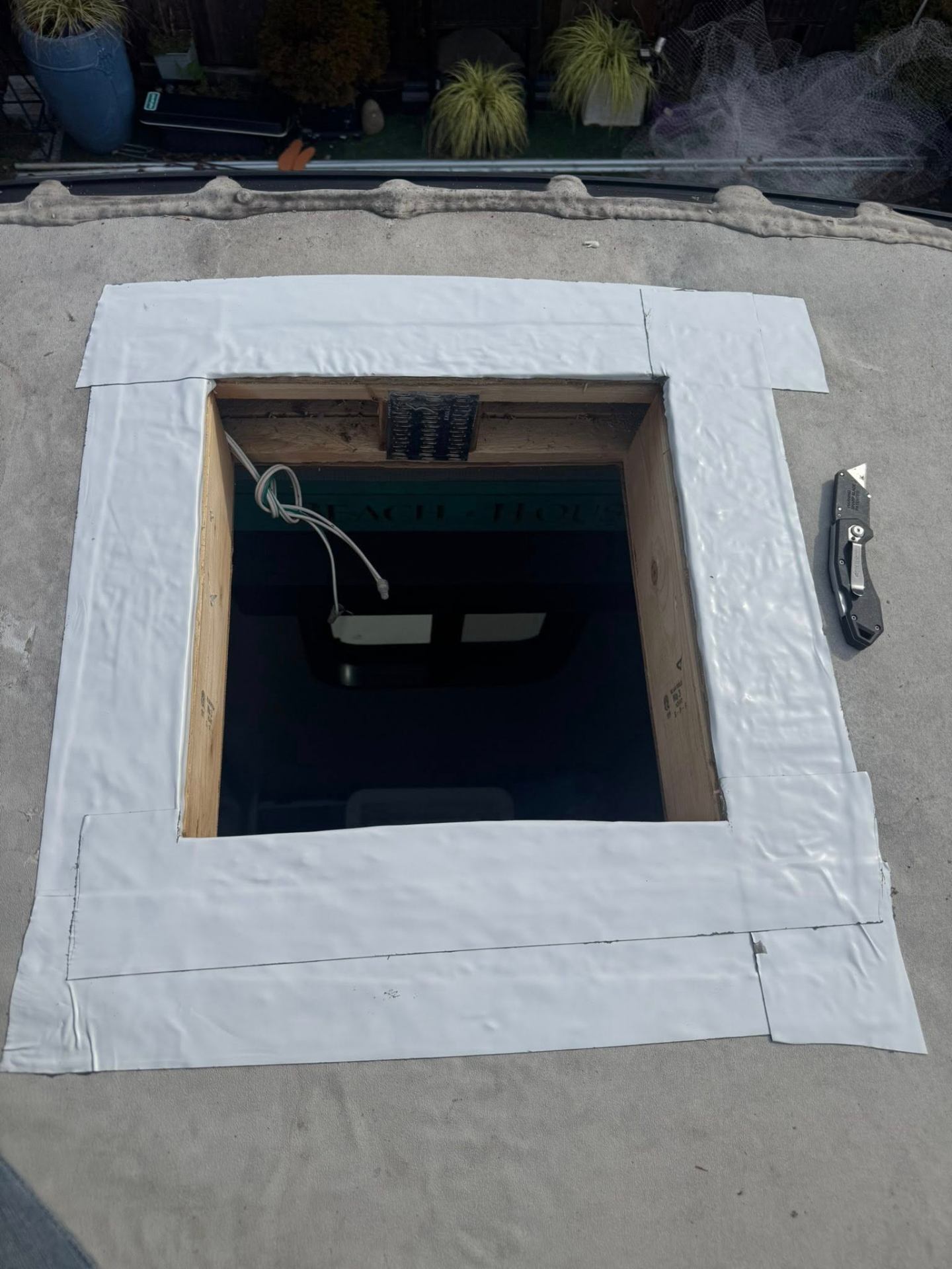Fresh butyl tape and membrane applied around an RV roof vent opening during the resealing process