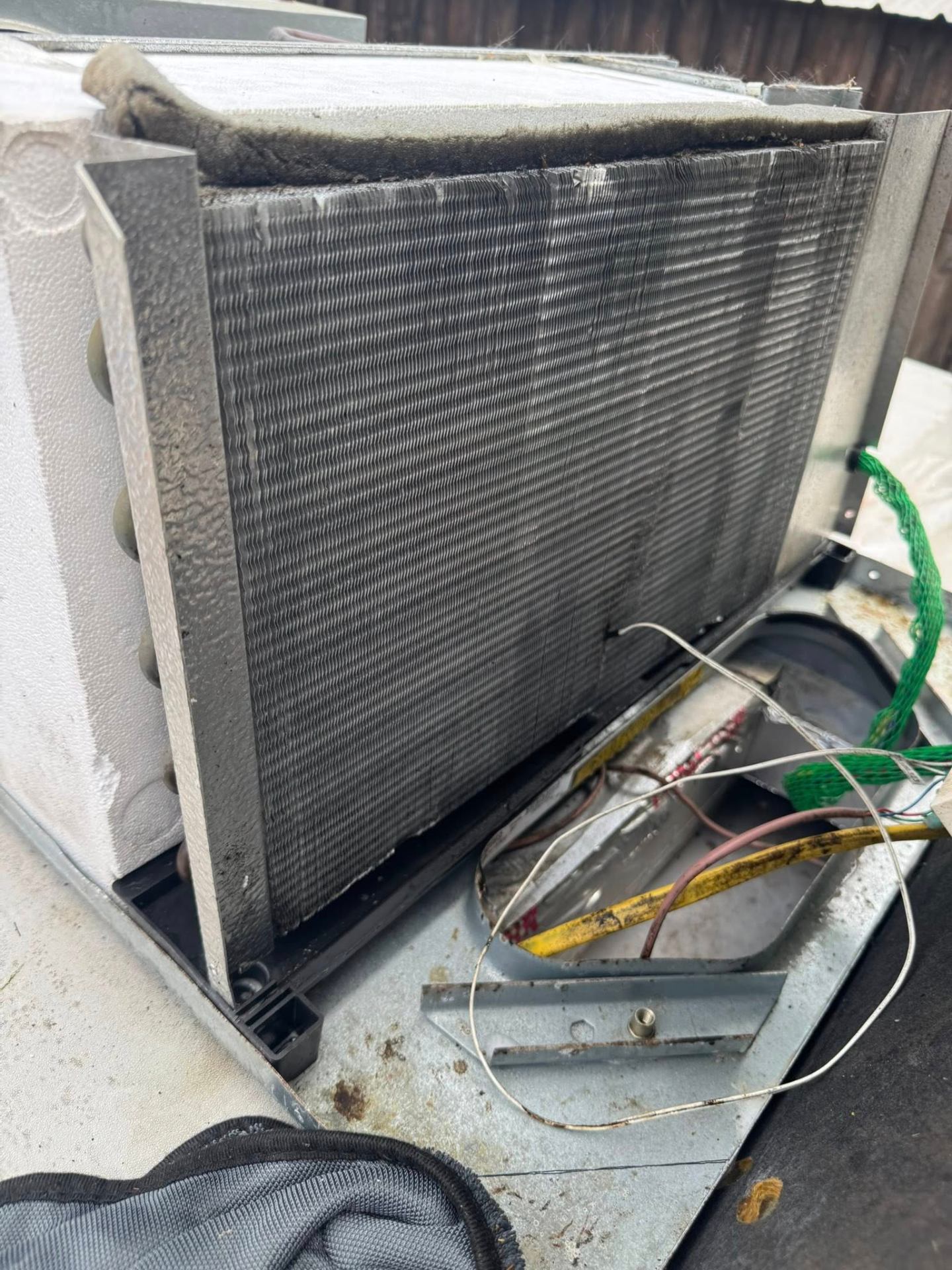 Dirty RV air conditioner condenser coil with dust and debris buildup before cleaning